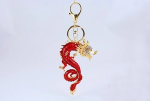 Detail of a Chinese dragon keychain with gold alloy finish, red enamel, and white rhinestones