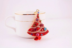 Detailed view of rhinestone Christmas tree pendant with vibrant red enamel and gold metal frame
