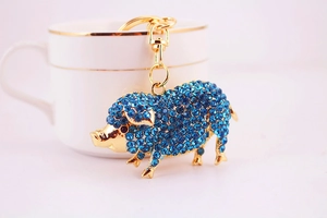 Gros plan détaillé du porte-clés cochon doré serti de cristaux et strass bleus brillants