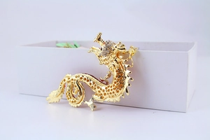 Detailed view of a golden dragon keychain with sparkling rhinestones and hollow metalwork