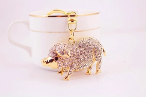 Vue détaillée du porte-clés cochon doré avec strass en cristal et fermoir homard