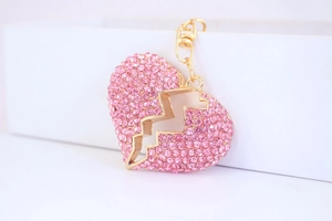 Nahaufnahme des rosa Kristallherz-Schlüsselanhängers mit Goldbeschichtung und Steinchen