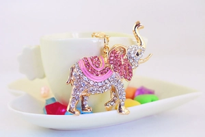 Porte-clés éléphant en métal doré orné de strass roses et blancs sur céramique