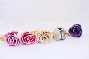 Vue détaillée des porte-clés rose en cuir en cinq couleurs avec anneaux dorés
