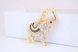 Close-up of sparkling rhinestone elephant pendant with gold-plated metal and enamel details