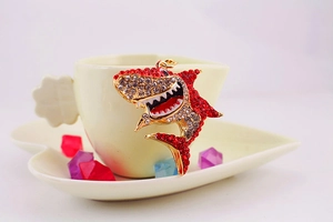 Vue détaillée du porte-clés requin serti de strass rouges et blancs sur une tasse