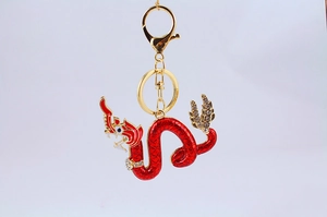 Dettaglio portachiavi drago in smalto rosso con cristalli intarsiati su placcatura oro