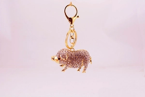 Gros plan détaillé du porte-clés cochon doré serti de cristaux de strass étincelants