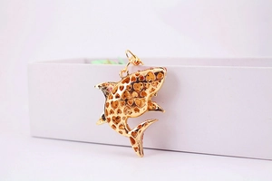 Détail du pendentif requin avec motifs en forme de cœur sur surface en métal doré