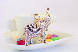 Vue détaillée du porte-clés éléphant avec strass brillants sur le bord d'une tasse