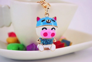 Dettaglio del portachiavi a maialino con casco blu, strass lucidi e nasino rosa carino