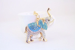 Vue macro du porte-clés éléphant en strass avec base dorée et cristaux bleus brillants