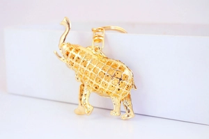 Macro shot of gold elephant keychain with rhinestone accents and hollow metal patterns