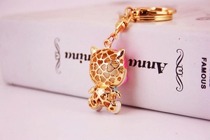 Dettaglio di un portachiavi Hello Kitty traforato placcato oro con motivi a cuore