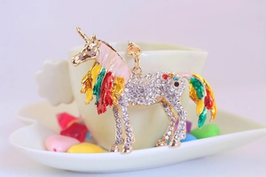 Detail of a gold-plated unicorn keychain with colorful rhinestones and enamel wings