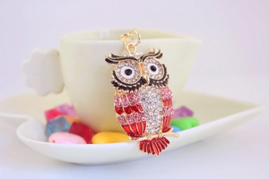 Détail du porte-clés hibou avec strass brillants et émail rouge sur une tasse