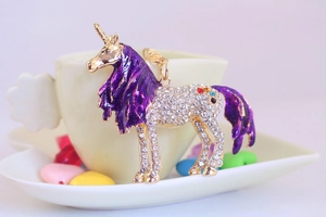 Close-up of crystal unicorn keychain with purple enamel mane and sparkling rhinestones