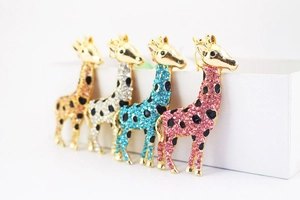 Close-up of sparkling rhinestone giraffe brooches in gold, silver, blue and pink