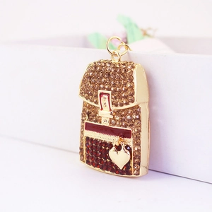 Macro detail of a heart-shaped backpack keychain with champagne and red rhinestones