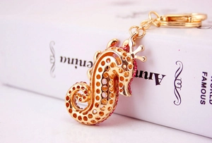 Macro view of gold seahorse keychain with red rhinestones and fine hollow structure