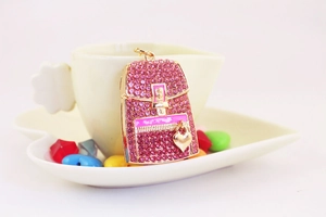 Detailed macro view of pink rhinestone mini backpack keychain with gold heart charm
