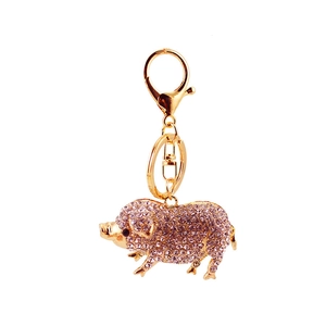 Porte-clés cochon en cristal rose avec fermoir en métal doré sur fond blanc