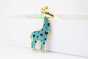 Makroaufnahme von elegantem Giraffenanhänger mit blauen Kristallen und Goldfinish
