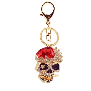 Porte-clés tête de mort doré avec strass et émail rouge pour sacs et voitures