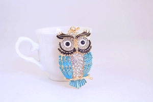 Détail du porte-clés hibou avec cristaux bleu ciel et métal doré poli et brillant