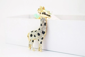 Makro-Detail von goldenem Giraffen-Schlüsselanhänger mit Kristallen und Herz-Mustern