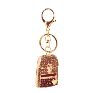 Macro shot of a mini backpack keychain featuring brown and red crystals and a heart charm