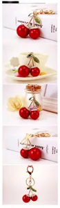 Close-up of sparkling crystal cherry keychain with red high-gloss finish and gold lobster clasp