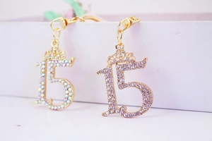 Macro detail of number 15 keychains with crown design and colorful rhinestones