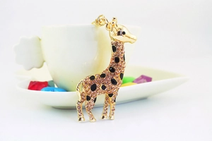 Detailed shot of a cute golden giraffe keychain with pink rhinestones and black enamel spots