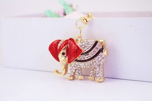 Close-up of golden elephant keychain with sparkling white crystals and enamel detailing