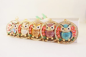 Detailed view of colorful rhinestone owl keychains featuring five vibrant color variants
