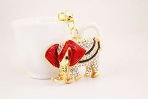Detailed macro view of golden elephant keychain with red enamel and white rhinestones