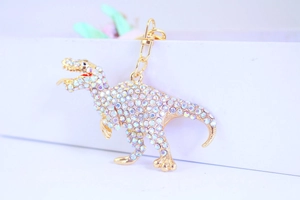 Close-up of sparkling rhinestone dinosaur keychain with golden metal lobster clasp