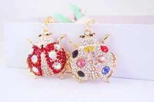Macro shot of rhinestone ladybug keychain pendants in red and multicolored gold plating