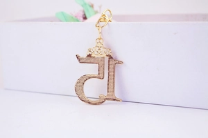 Macro shot of gold hollow number 15 keychain with mini crown and lobster clasp