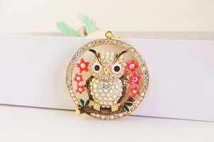 Detail of owl keychain with sparkling AB rhinestones and pink enamel flowers