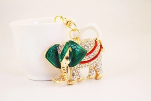 Close-up of golden elephant keychain with green enamel ears and sparkling rhinestones