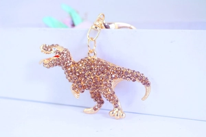 Macro detail of dinosaur keychain with sparkling champagne crystals and golden alloy clasp