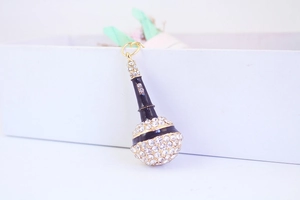 Close-up of a creative black microphone keychain with sparkling rhinestones and gold accents