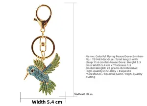 Gros plan du porte-clés oiseau en strass avec cristaux bleus et verts sur alliage de zinc doré