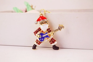 Détail du Père Noël avec guitare serti de cristaux et finitions en émail coloré