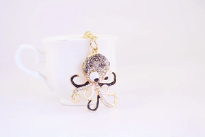 Detailed view of octopus keychain with black and white rhinestones on golden alloy base