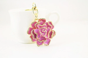 Close-up of pink-purple floral keychain with sparkling rhinestones and gold-tone finish