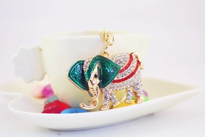 Close-up of golden elephant keychain with sparkling rhinestones and green enamel details
