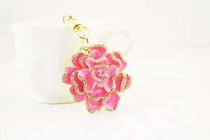 Detail of rhinestone petal edges on pink rose keychain with golden metal finish